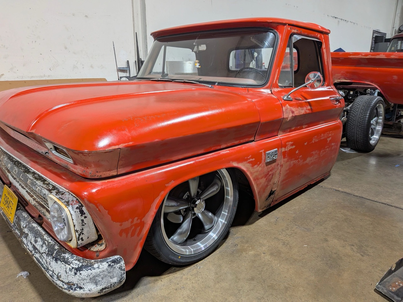Lowered red Chevrolet C10 custom build inside the shop