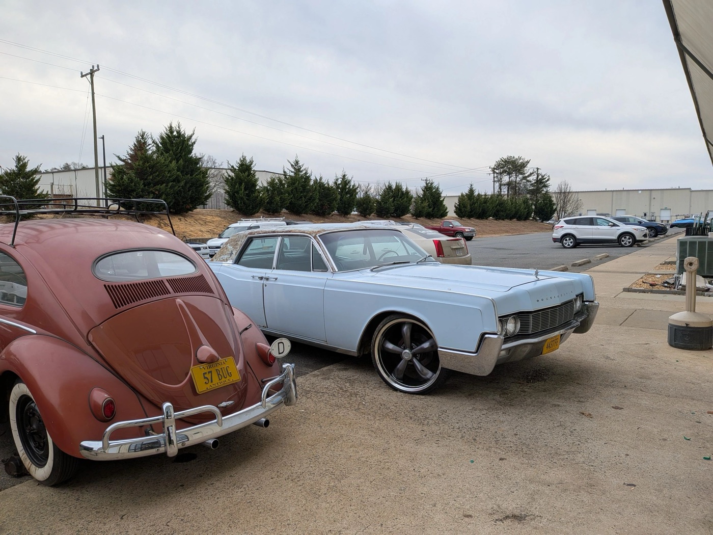 A Volkswagen Beetle and classic Lincoln outside the BuiltWright shop